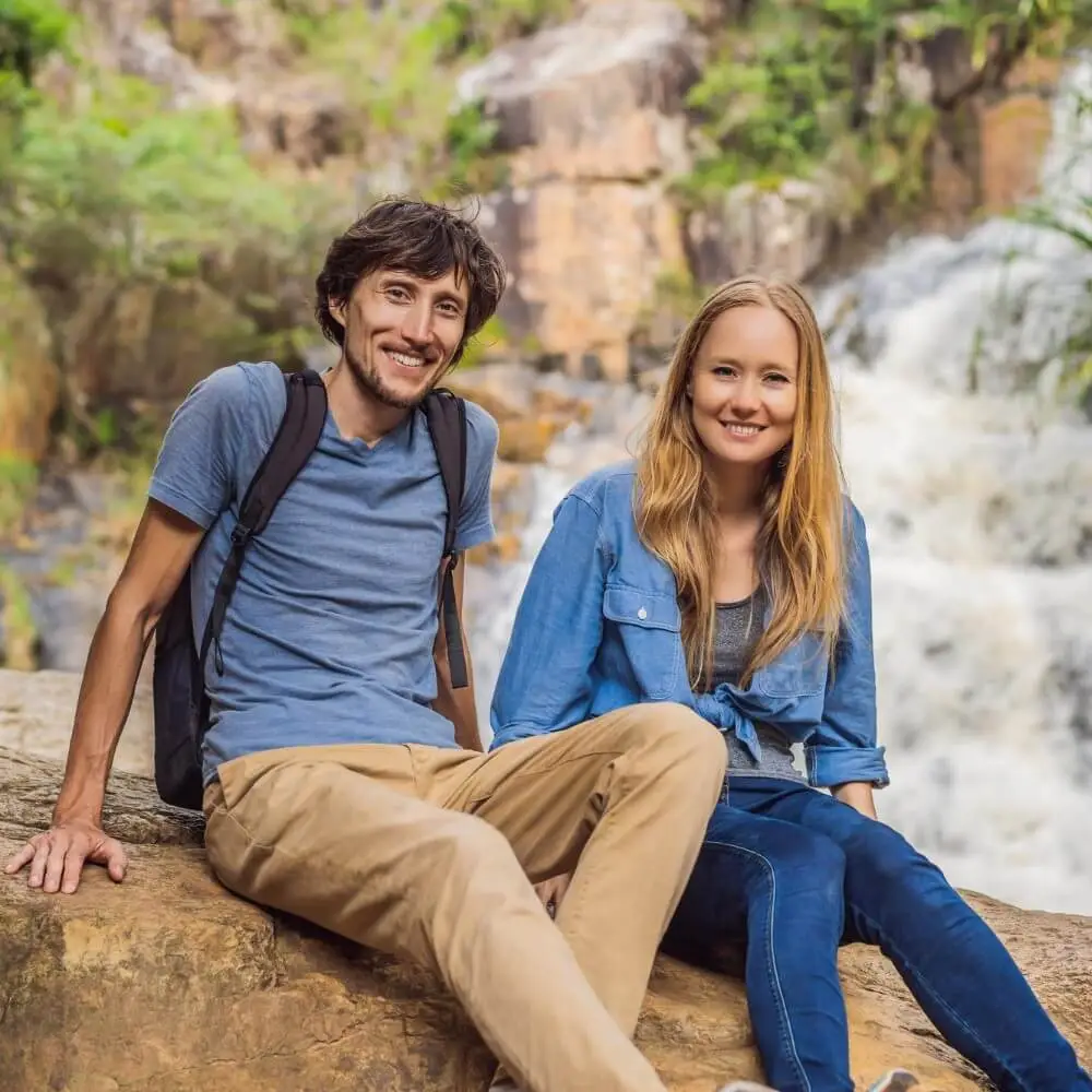 couple tourists with backpack background waterfall